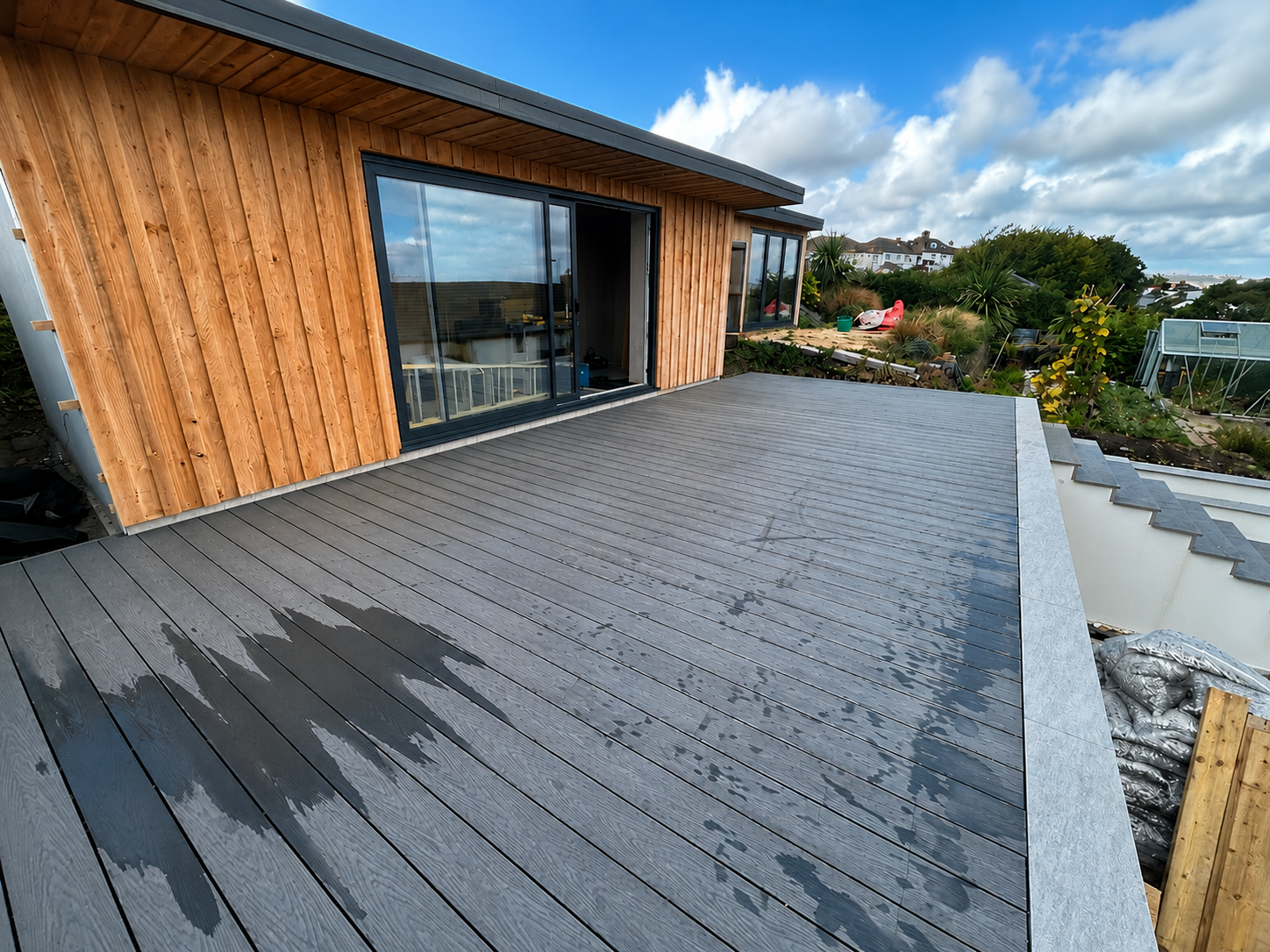 Bespoke timber-clad garden room with composite decking by Goss Carpentry